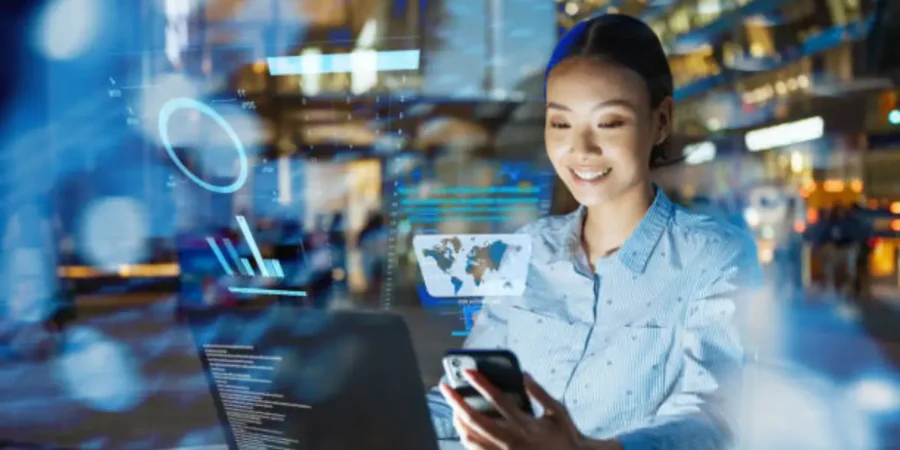 Mujer sonriendo mientras trabaja con inteligencia artificial y analiza datos digitales en su computadora
