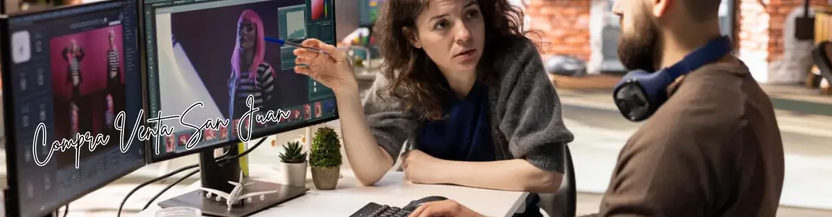 Mujer y hombre trabajando juntos en edición digital frente a dos monitores en oficina creativa
